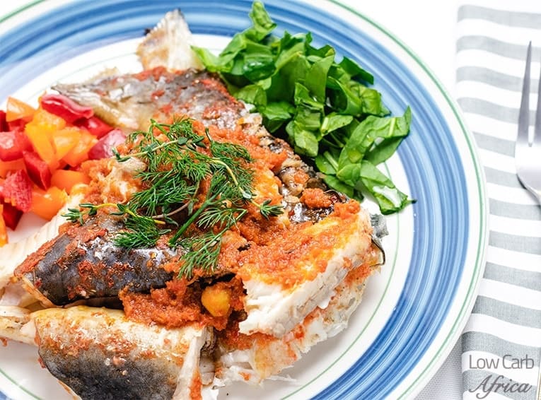 recipe for spicy whole oven baked fish on a blue and white plate.