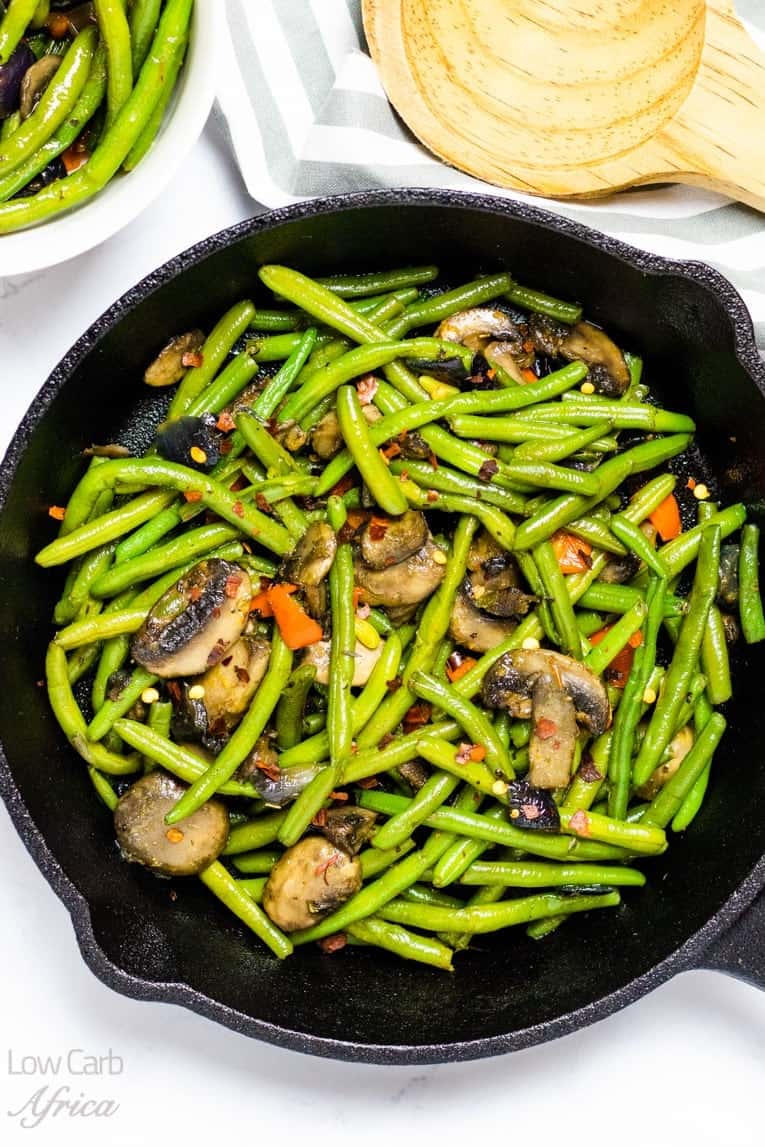 sauteed green beans and mushrooms on a skillet.