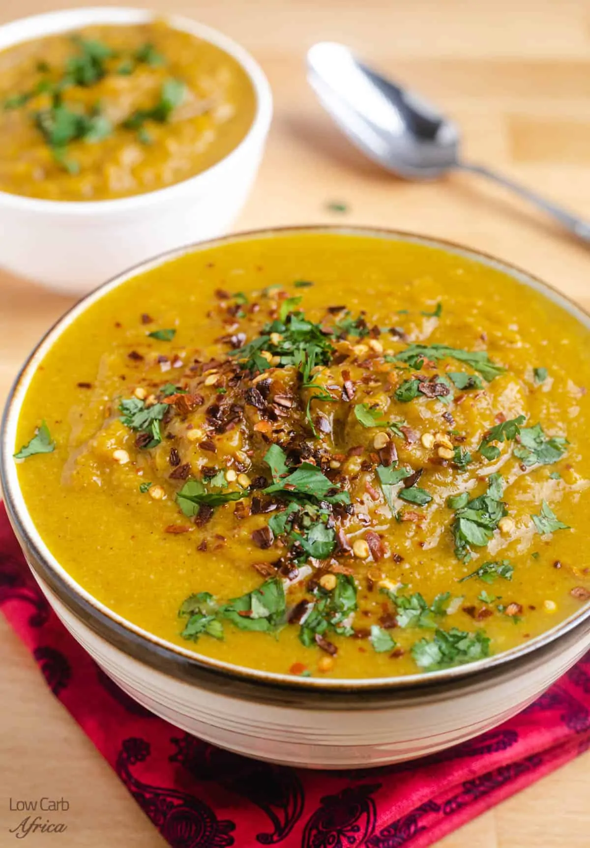 spicy soup made with pumpkin and topped with chopped cilantro.