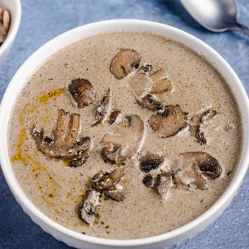 Wide image showing a bowl of soup with mushrooms