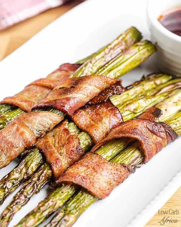 bacon wrapped asparagus on a white platter