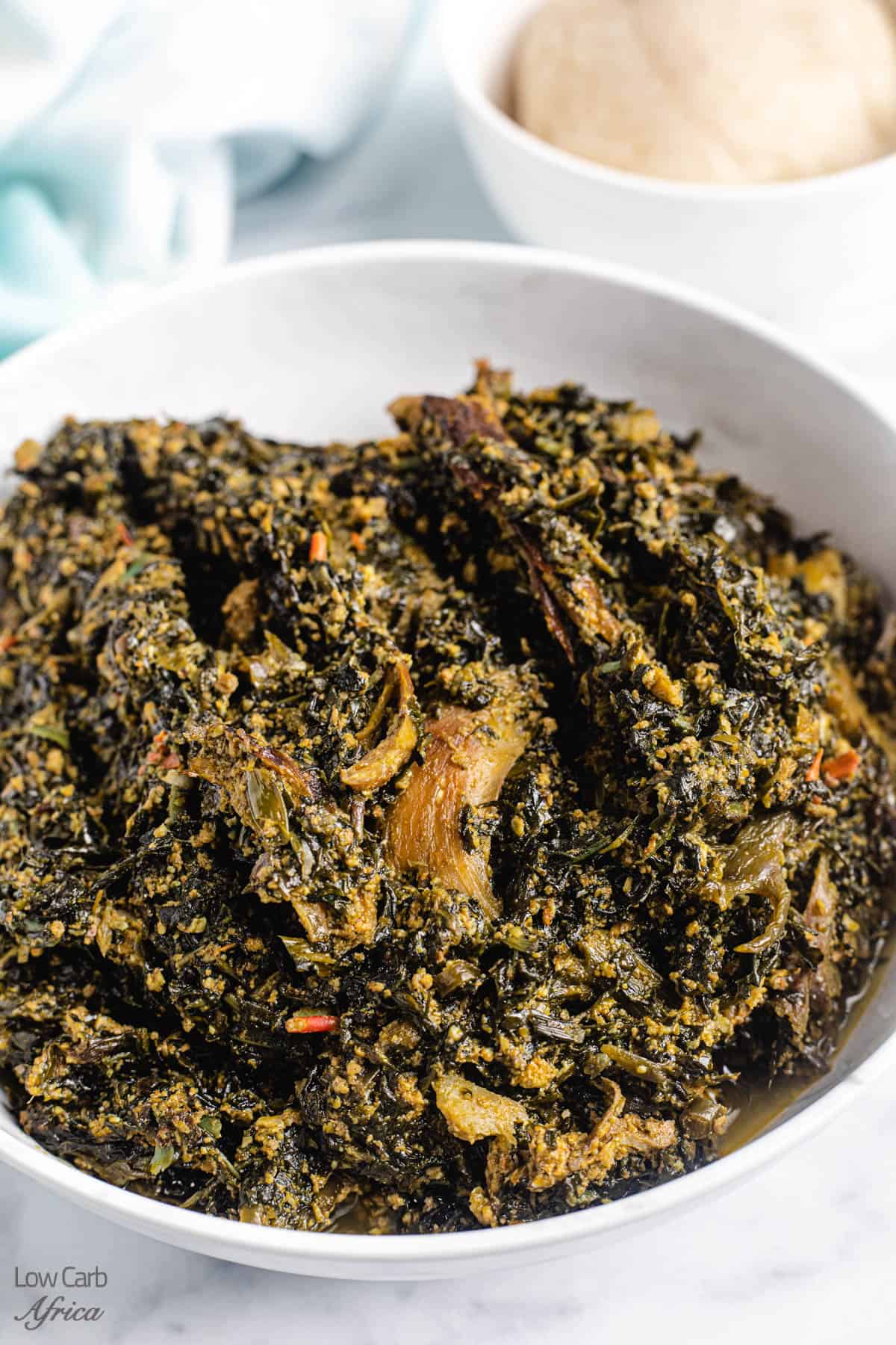 Nigerian bitter leaf soup in a white bowl