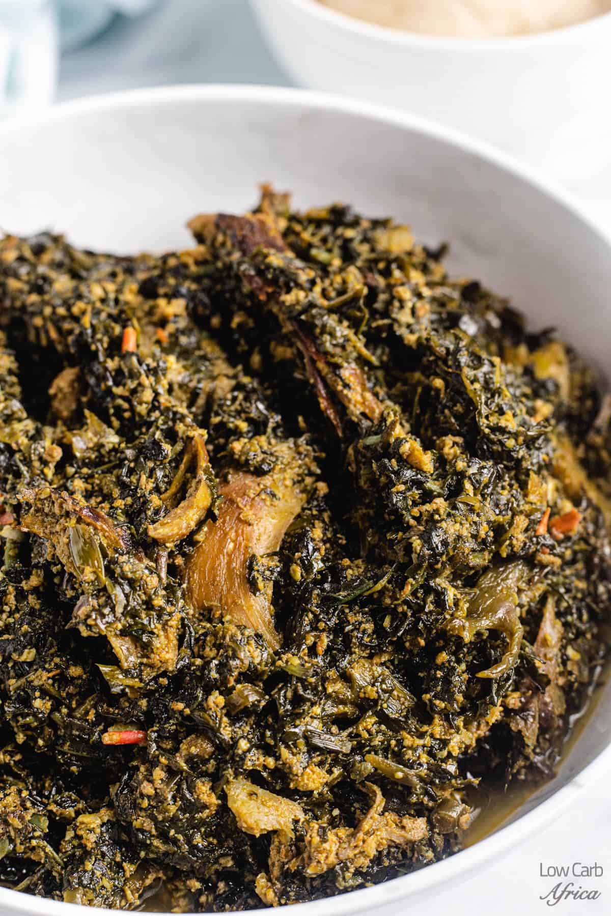 Nigerian bitter leaf soup in a white bowl