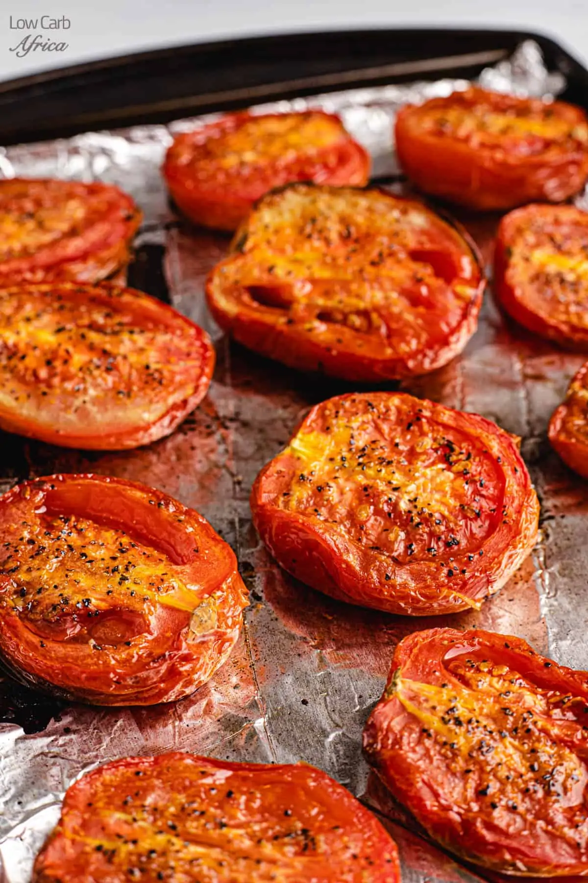 several pieces of roasted tomatoes on foil lined tray