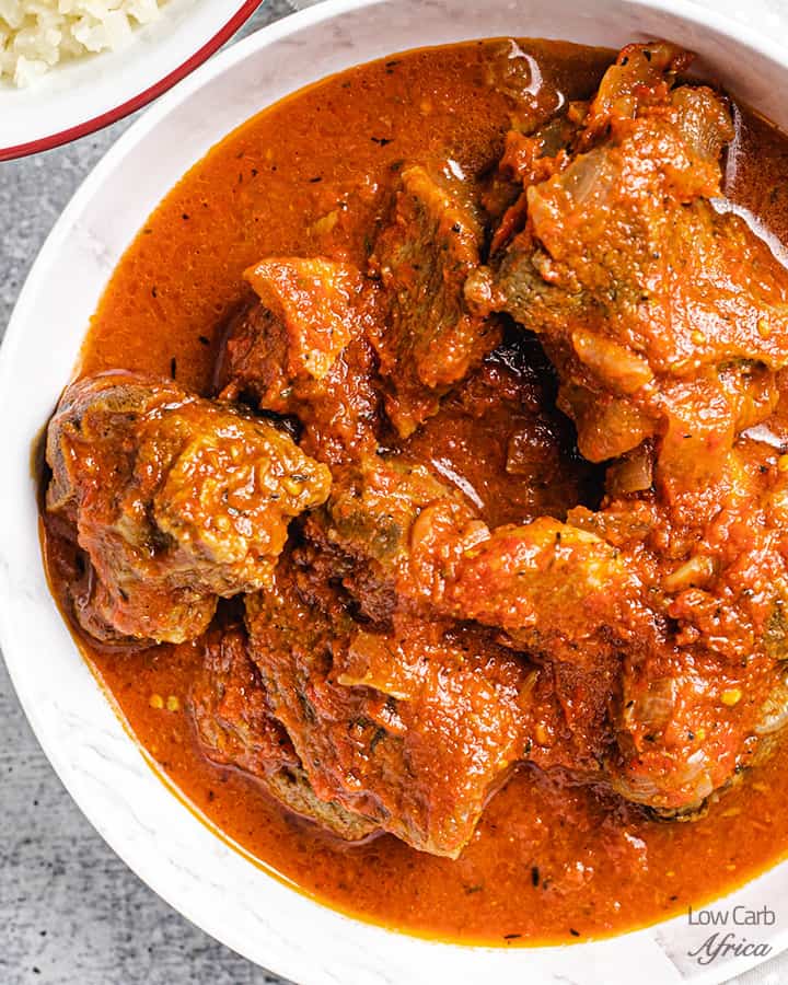 close up image of goat stew in tomato sauce