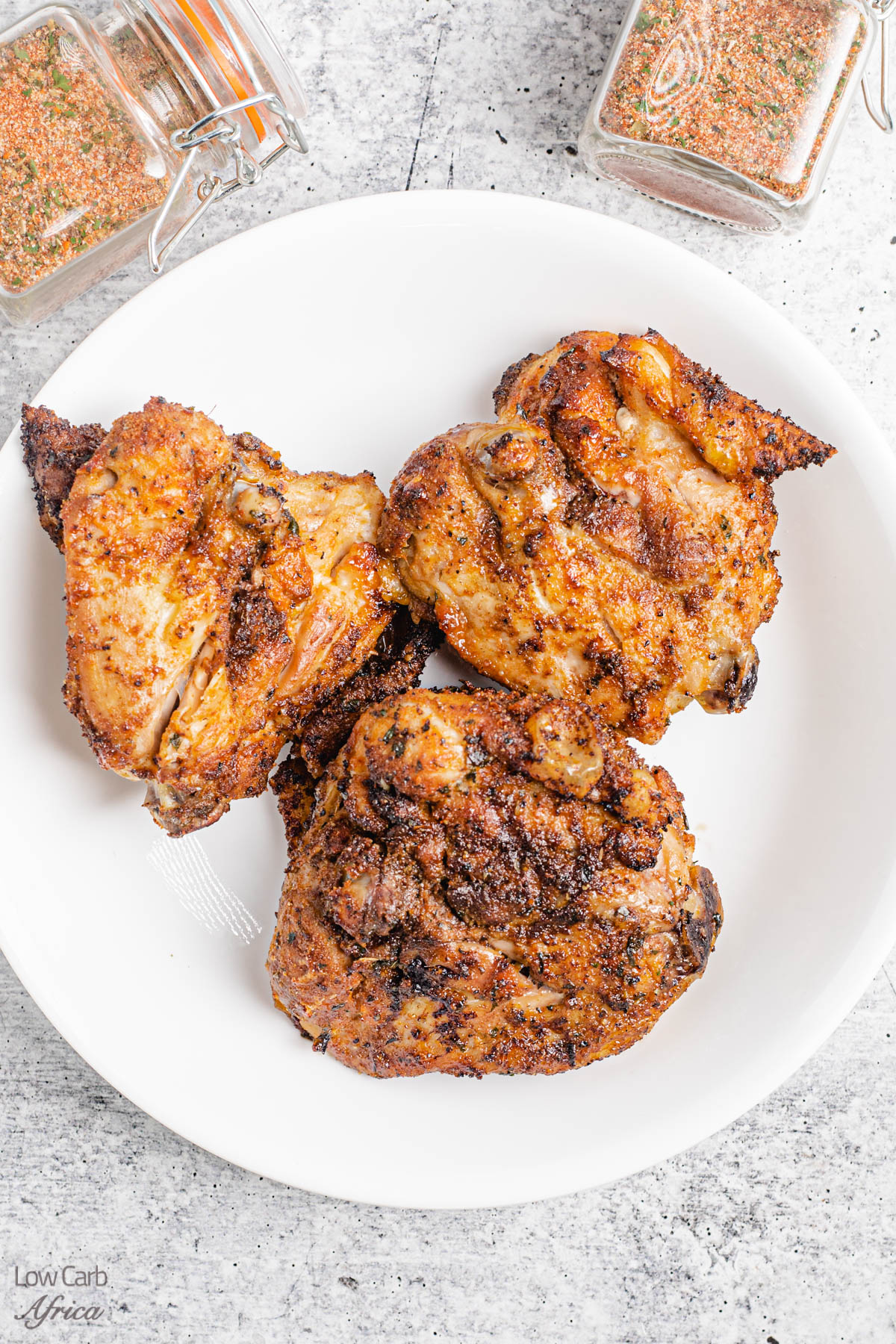 chicken seasoned with homemade spice rub on a white plate.