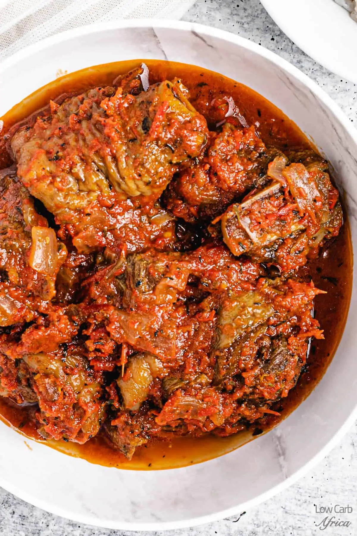 African turkey stew in a white bowl on a white counter.