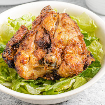 Air Fryer Bone-In Chicken Thighs on a bed of lettuce