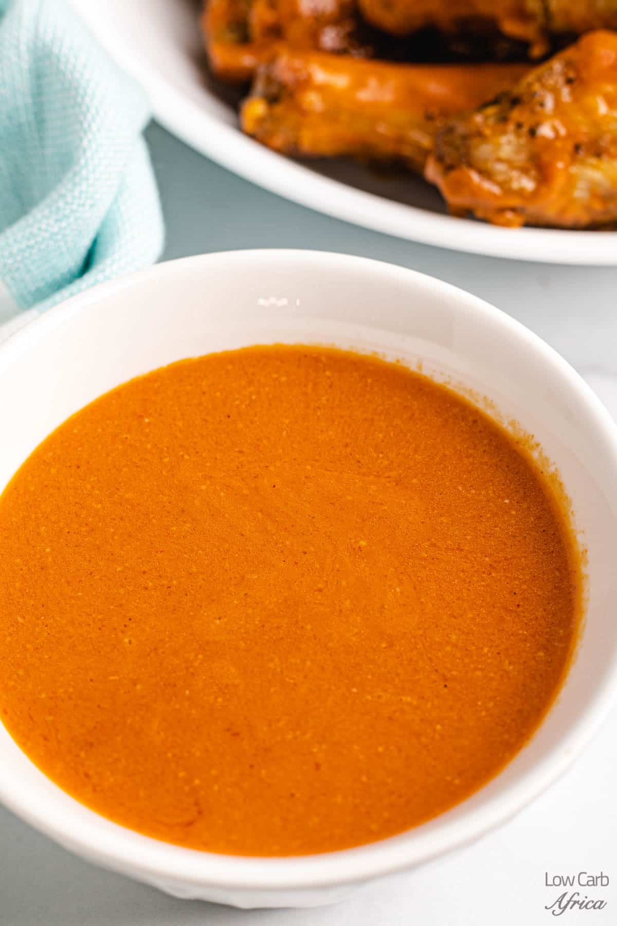 close up shot of buffalo sauce in a white bowl