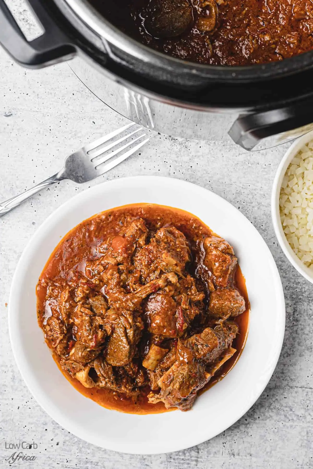 instant pot african lamb stew served on a white plate.