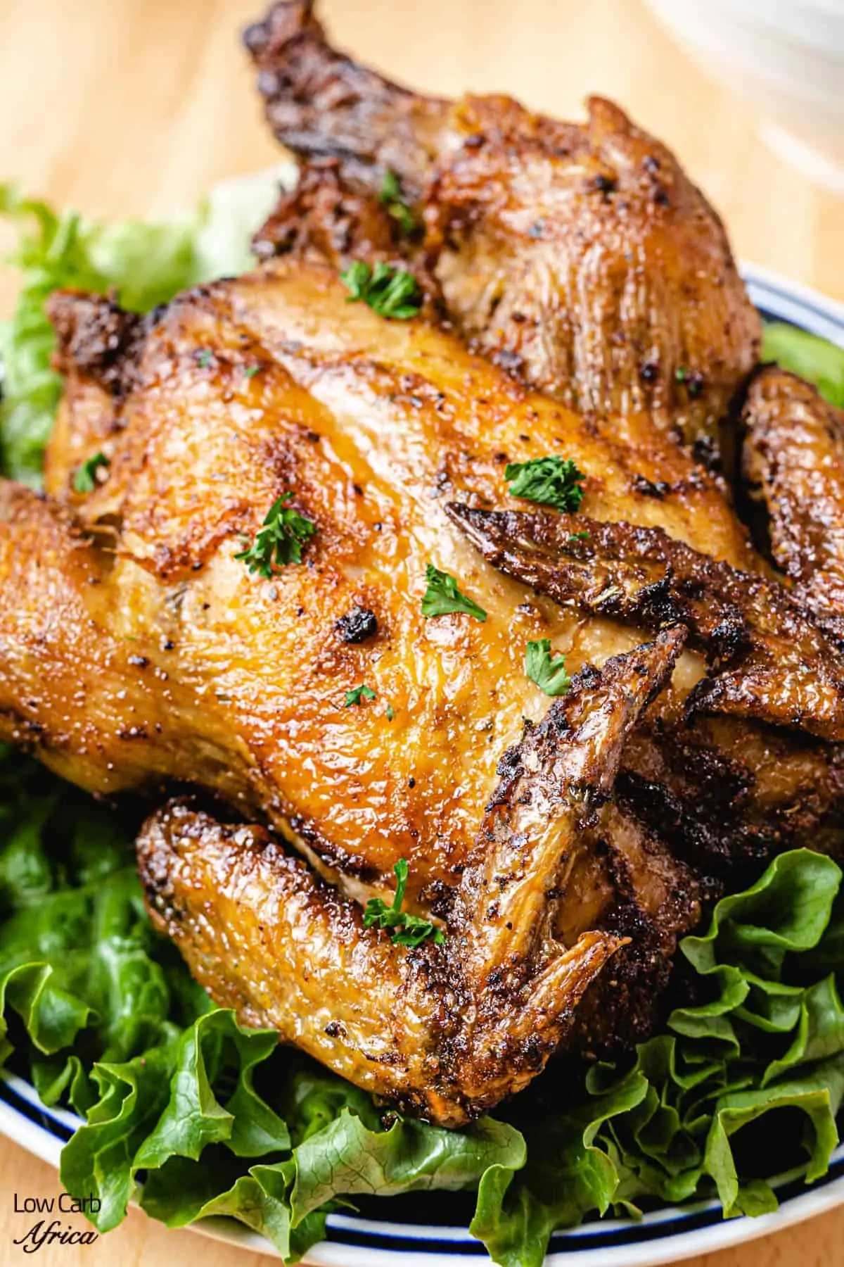 air fryer cornish hen on a bed of lettuce.