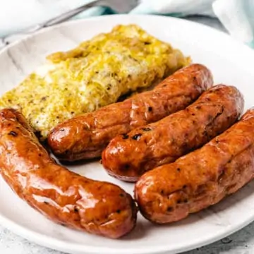 sausages served with omelet on a white plate