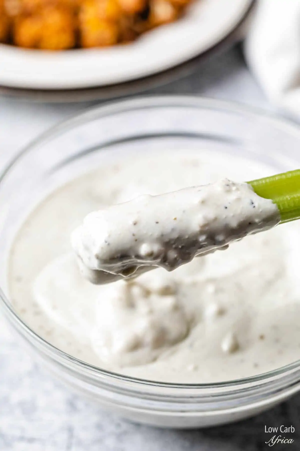 scooping out cheese dressing with celery.
