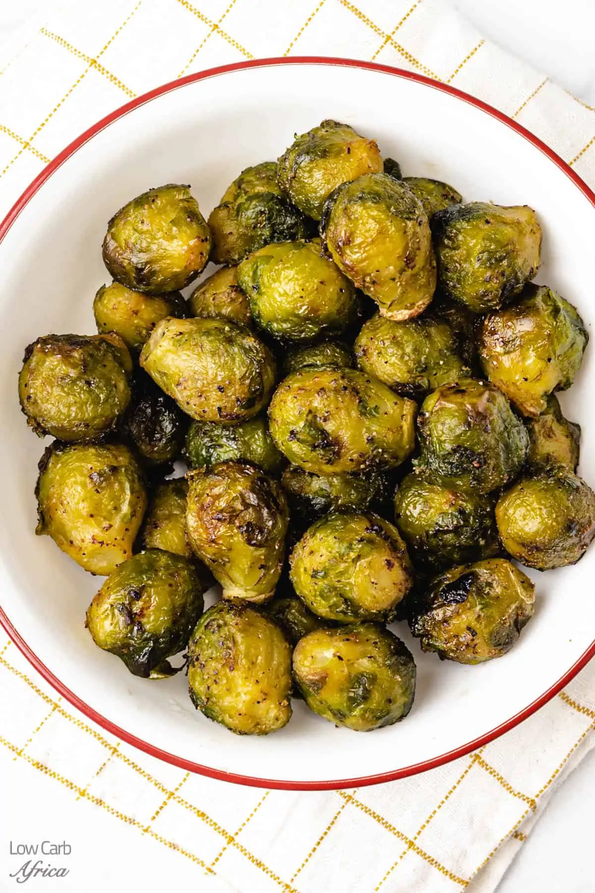 air fryer frozen brussels sprouts on a white plate ready to eat.