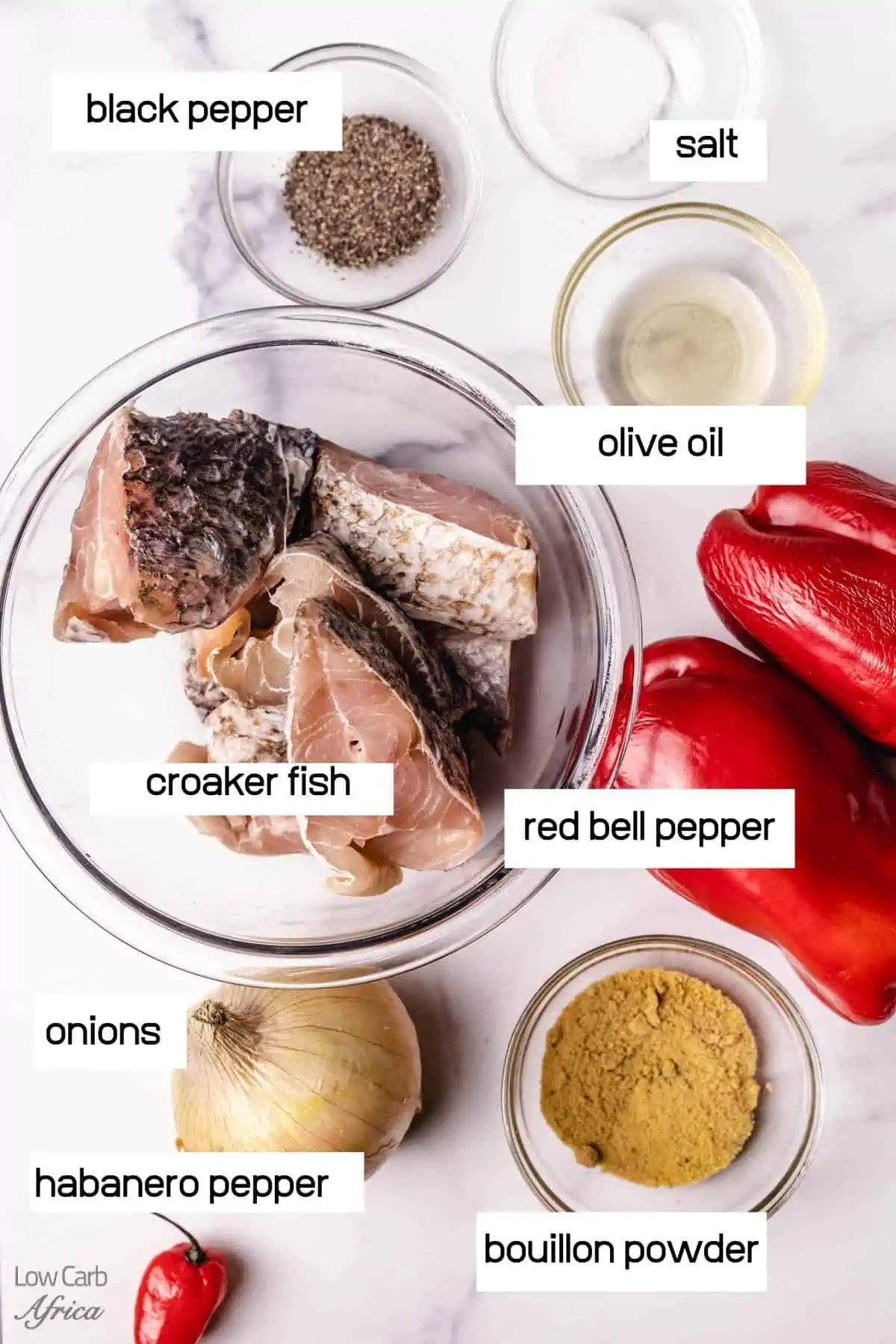 ingredients to make croaker fish including oil, spices, red bell pepper, onion, and habanero pepper.