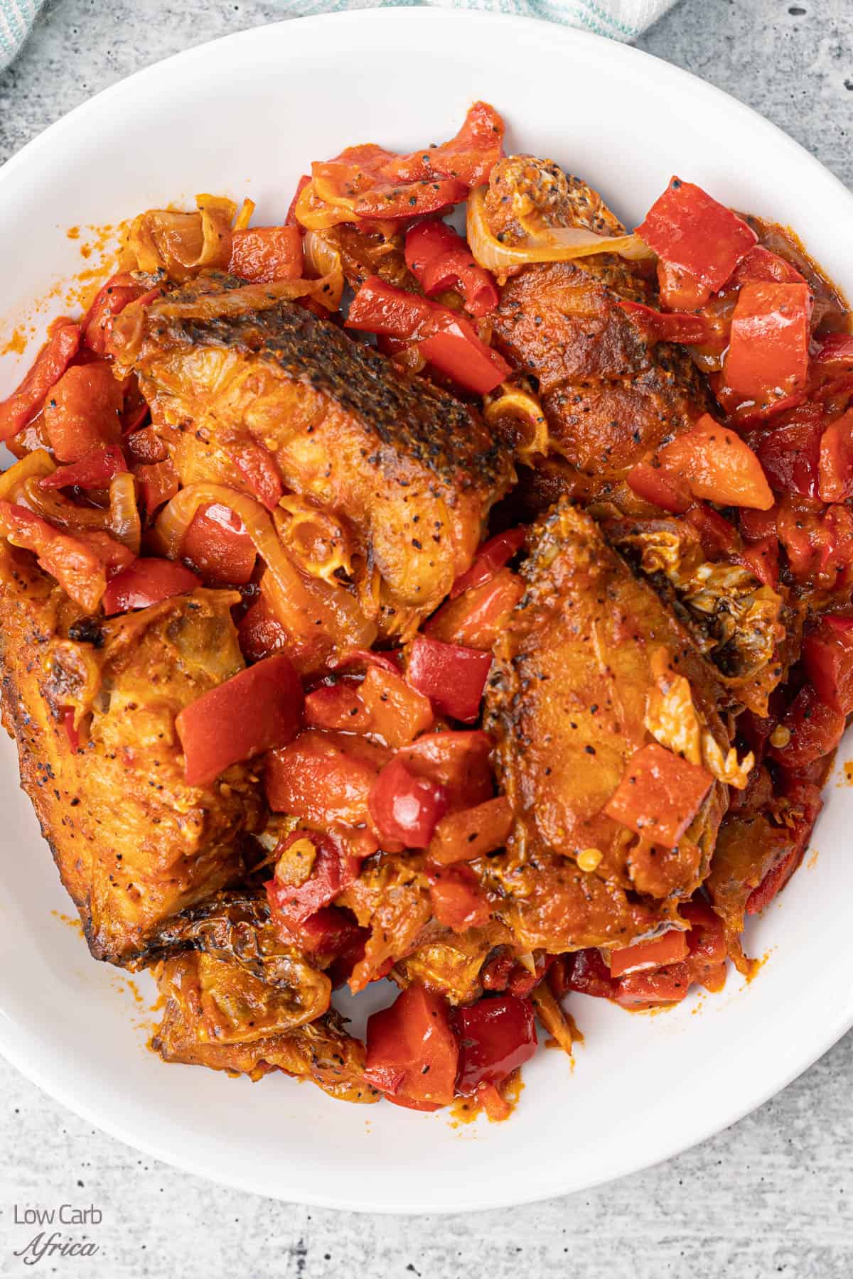 peppered croaker fish in a white plate.