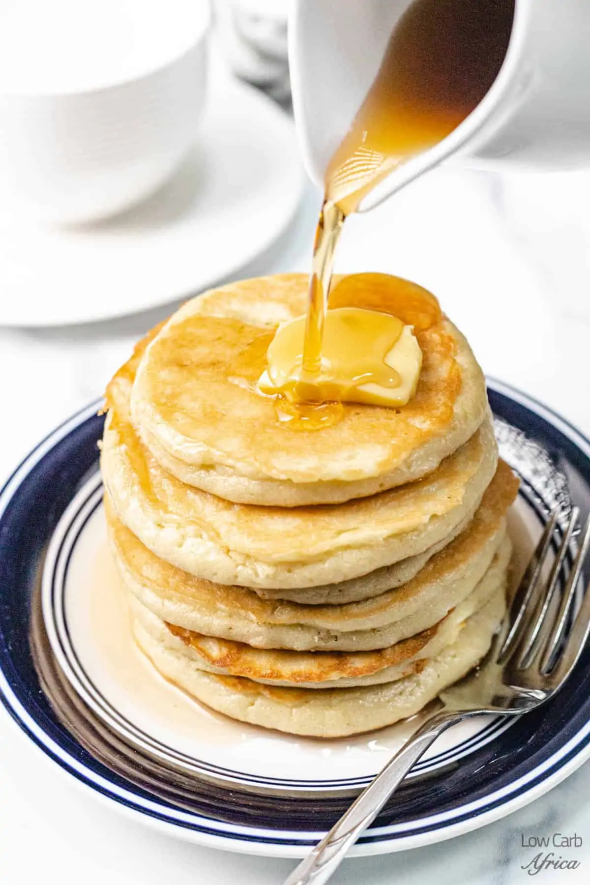 pouring syrup on keto pancakes