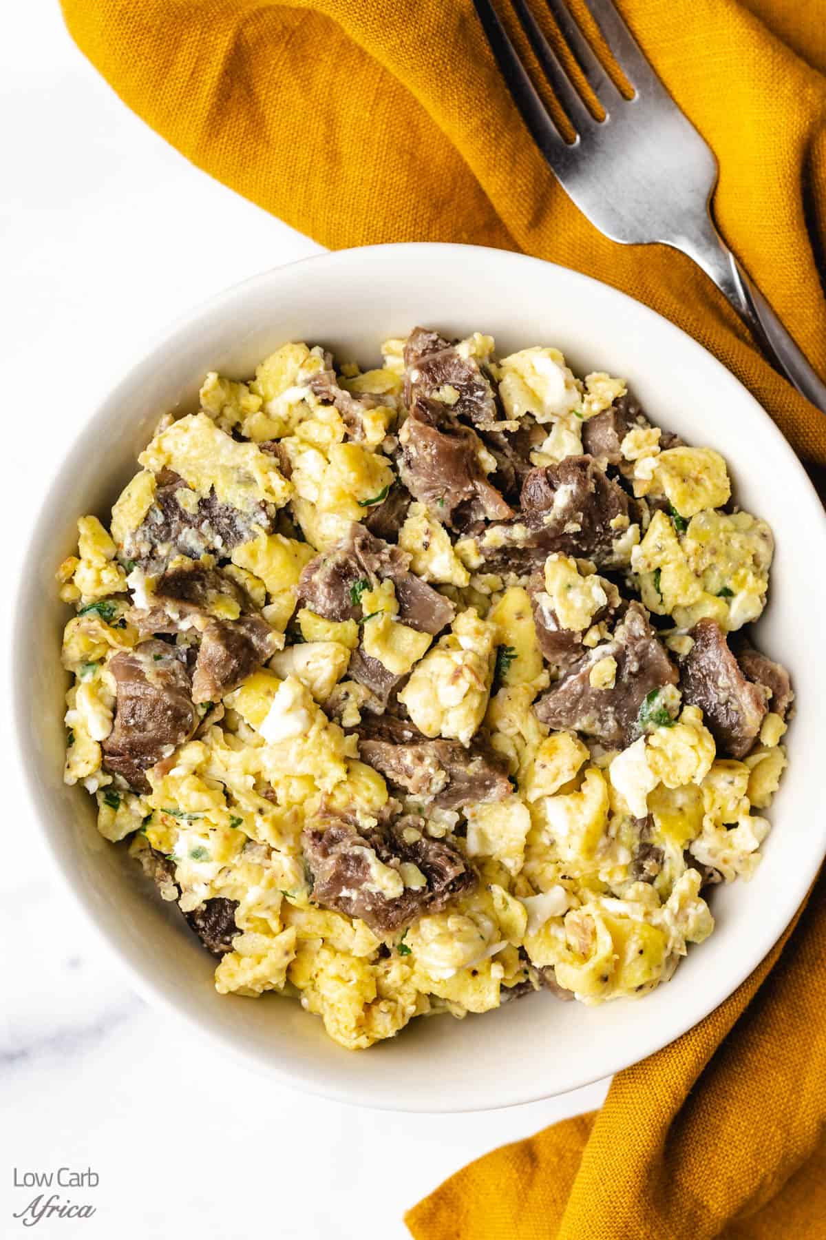 steak and egg scramble served on a white plate