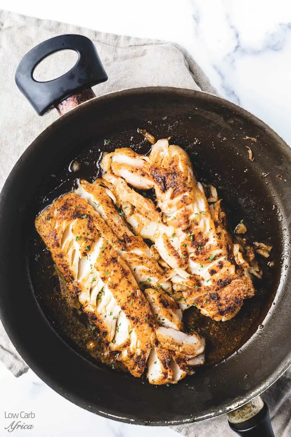 pan seared codfish in a skillet