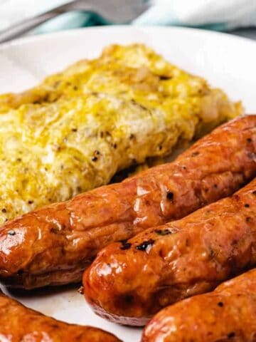 sausages served with omelet on a white plate