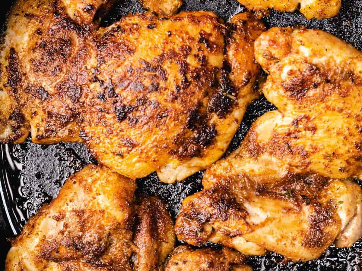 pan fried chicken thighs in a skillet.
