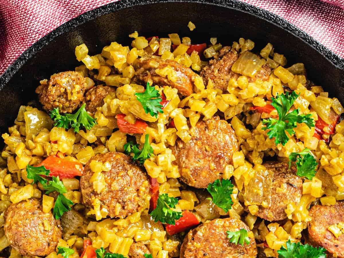 skillet with sausage peppers and cauliflower rice.